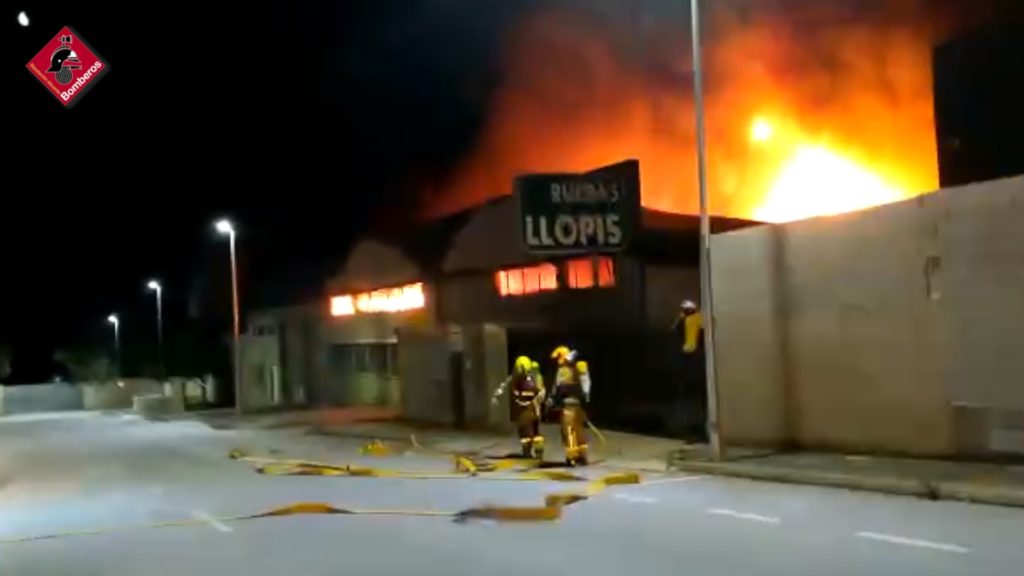 Los bomberos trabajan en la extinción de un incendio declarado en una nave de neumáticos