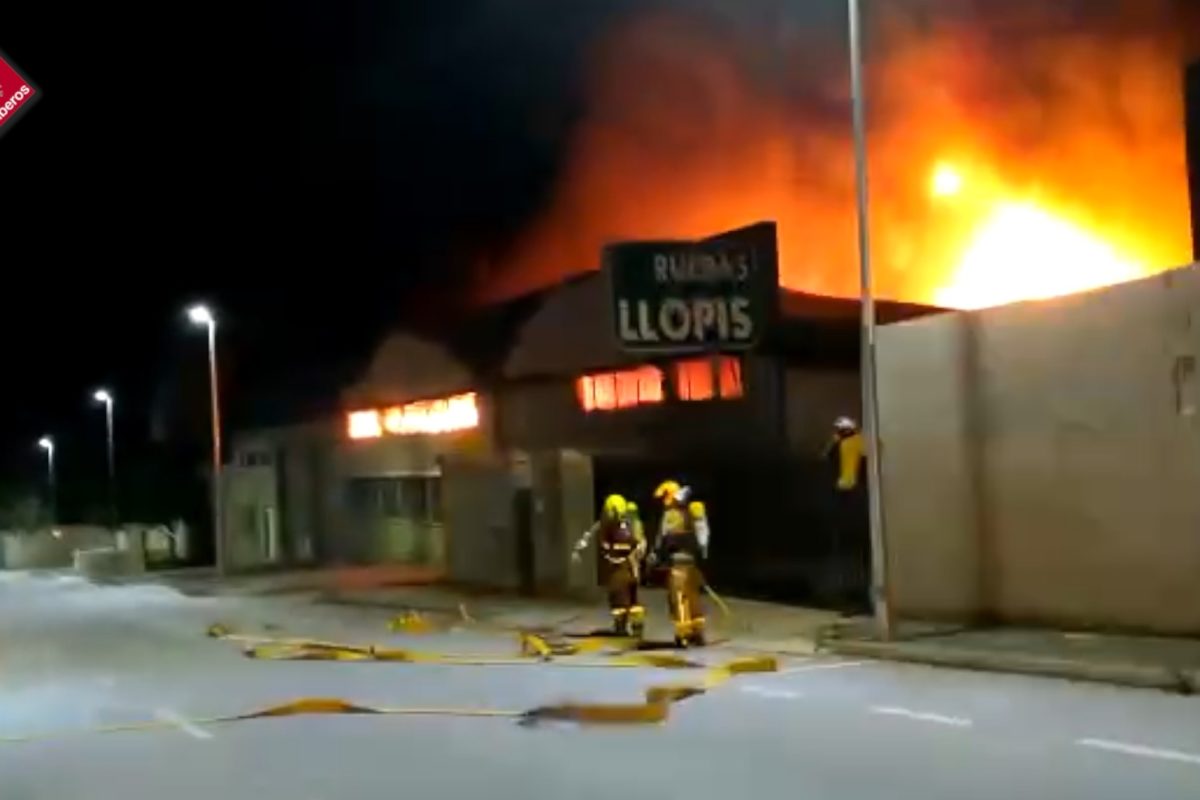 Los bomberos trabajan en la extinción de un incendio declarado en una nave de neumáticos