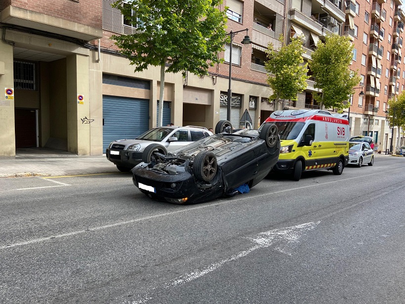 Aparatós accident al carrer Oliver que deixa un cotxe bolcat