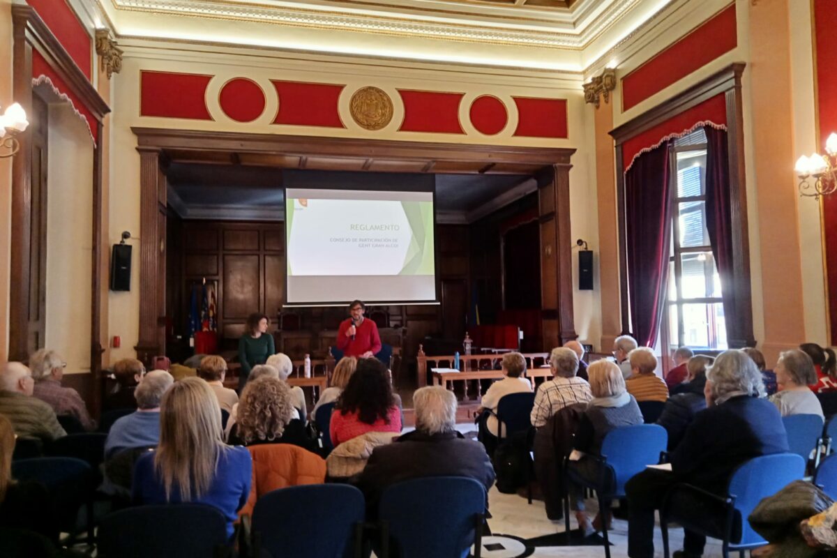 El Ayuntamiento de Alcoy quiere incorporar la visión y participación de las personas mayores a las políticas de la ciudad. Por eso, el pasado jueves 29, el equipo técnico del departamento presentó en la Sala de Plenos del consistorio un borrador del reglamento de funcionamiento del Consejo de Participación de Personas Mayores, dando 15 días hábiles para que las entidades, centros y colectivos relacionados con las políticas de Gent Gran puedan hacer sus aportaciones de mejora del documento. Una vez se incorporen o no las posibles aportaciones, empezará el circuito administrativo para su aprobación en el Pleno. Algunos de los objetivos que recoge el texto son promover la solidaridad social y la participación ciudadana, con el fin de incrementar la corresponsabilidad en la atención de personas mayores. También pretende potenciar la participación social, política y cultural de las personas mayores en igualdad de condiciones con otros sectores de la población, velar por el ejercicio eficaz de los derechos de las personas mayores en el ámbito local, así como acoger la experiencia y riqueza cultural de las personas mayores, potenciando su autovaloración y creatividad. El Consejo tendrá algunas de las siguientes funciones: elevar a los órganos de gobierno propuestas e iniciativas para mejorar las actuaciones municipales en el ámbito de las personas mayores, participar en el diseño de programas y campañas dirigidas a fomentar la participación del colectivo y asesorar en el Ayuntamiento en iniciativas y sugerencias. Según el texto propuesto, estas funciones se llevarán a cabo a través de mesas de trabajo, que irán creándose en función del proyecto o ámbito temático que se trabaje. Recordamos que Alcoy forma parte del proyecto “Ciudades Amigables con las personas mayores – Age Friendly Cities (AFC)”desde 2019, una iniciativa recomendada por la OMS en 2007 con un objetivo fundamental: afrontar dos de los retos demográficos surgidos en el ámbito global: el envejecimiento de la población y el proceso de urbanización. Se considera que una ciudad es amigable si adapta sus estructuras y sus servicios porque resultan accesibles e integran a las personas mayores con diferentes necesidades y capacidades. El proyecto AFC ha facilitado la creación de una Red Mundial de Ciudades y Comunidades Amigables con las Personas Mayores, como instrumento de intercambio de conocimientos, experiencias y buenas prácticas con el fin de adaptar los entornos urbanos y sociales a las necesidades de las personas de mayor edad. La concejala de Gent Gran, Aroa Mira, destaca que, «Para el Gobierno Municipal es seguir trabajando para afrontar un reto importante cómo es el envejecimiento de la población. Trabajamos para que los servicios sean accesibles y adaptados a las necesidades de las personas mayores. La creación de este Consejo nos ayudará a actuar conociendo de primera mano qué son las necesidades y qué son las ideas que las personas mayores nos puede aportar