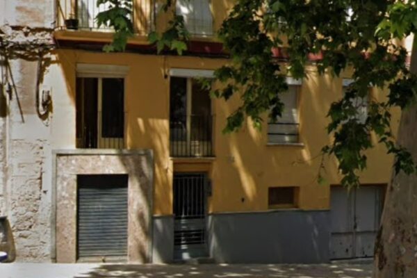 Una dona dona a llum en un portal del carrer Sant Mateu